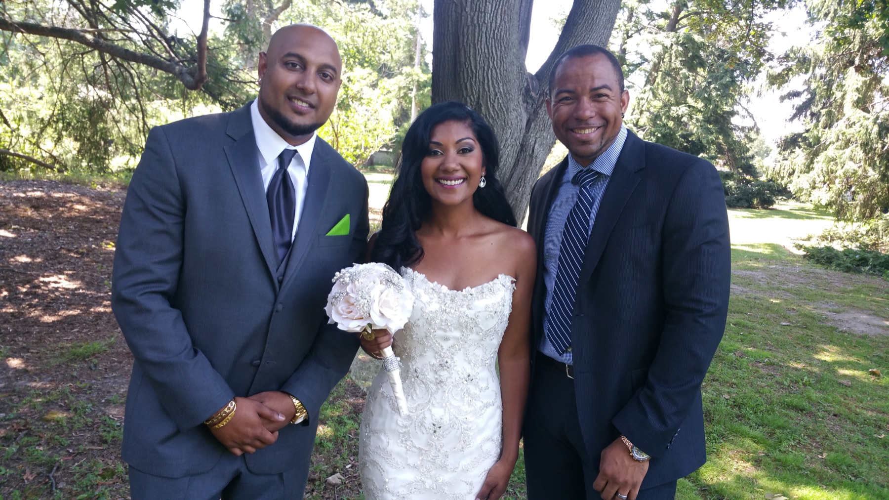Wayde posing with newlyweds after their outdoor ceremony