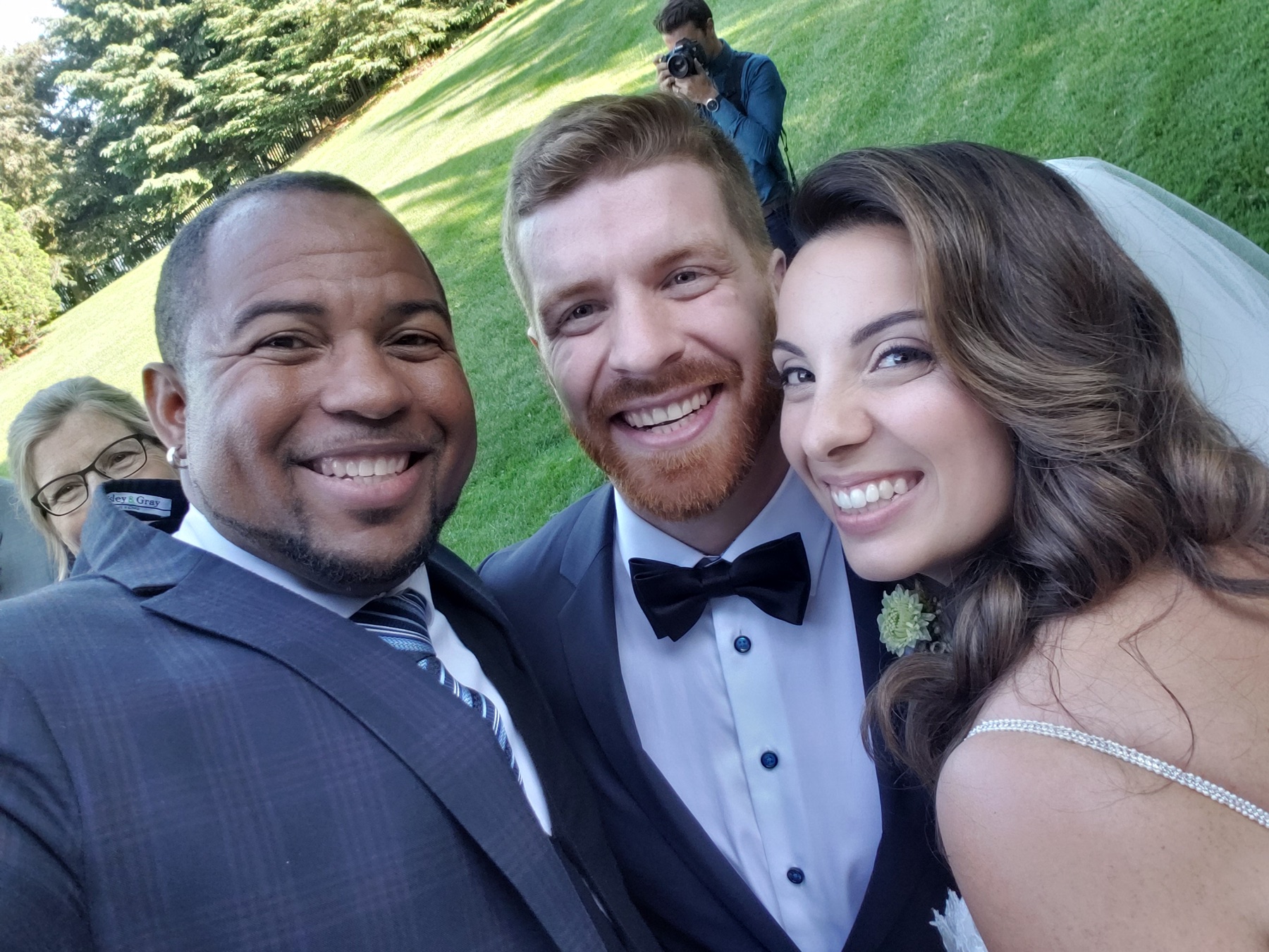 Wayde sharing a joyful selfie with newlyweds outdoors