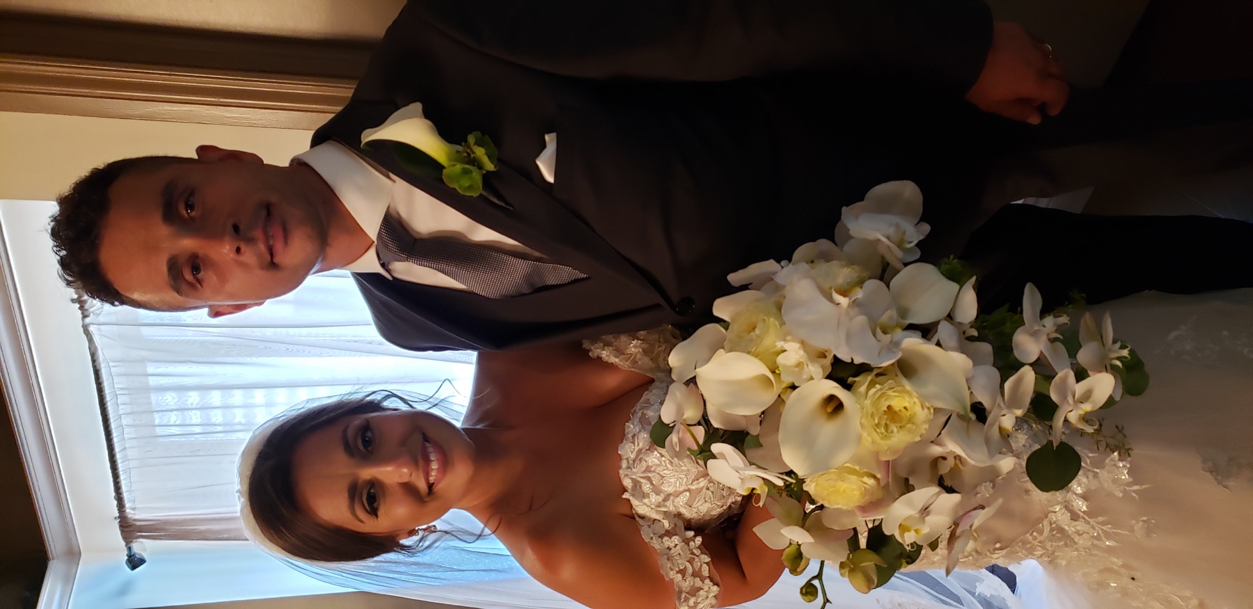 Newlyweds with an elegant white floral bouquet
